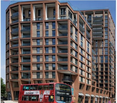 Brick façade of 34 Wembley Hill Road with a red London bus passing